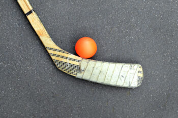 Hockey Stick with Orange Ball on Asphalt